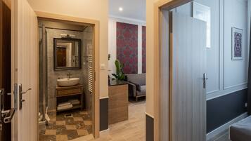 A modern bathroom with a sink, mirror, and towel rack.