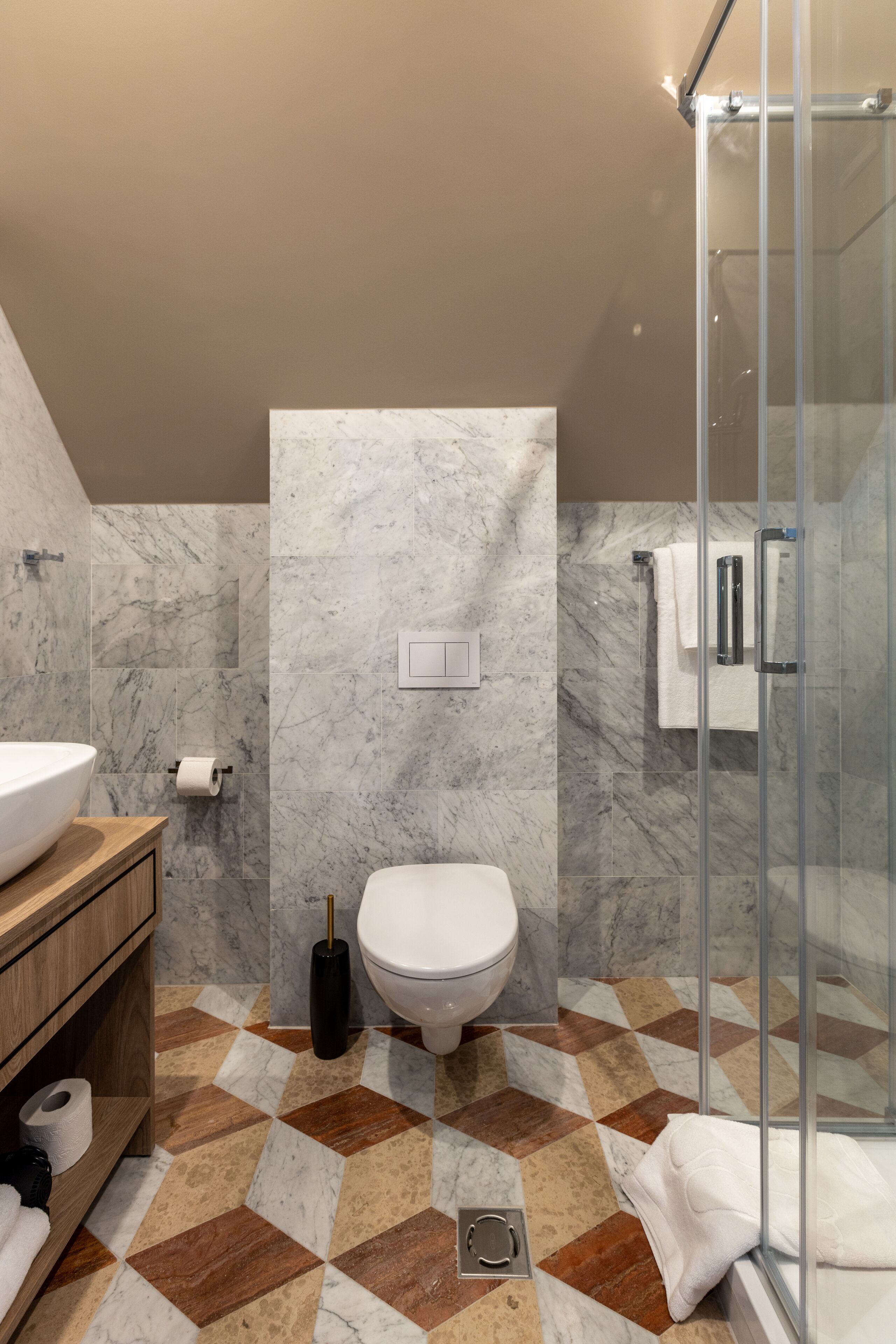 Une salle de bain moderne avec un sol en marbre, une douche en verre et un meuble-lavabo en bois.