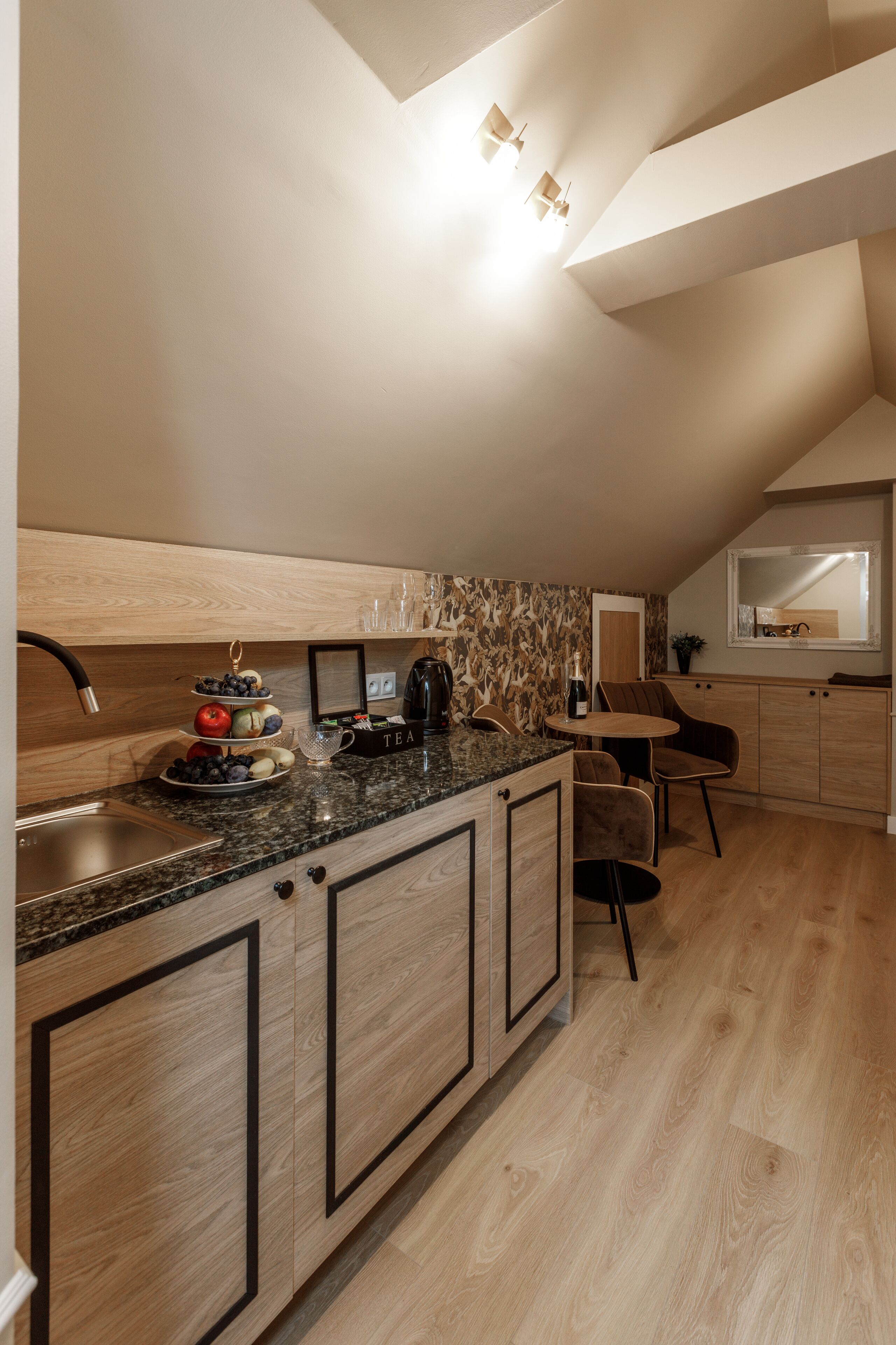 Una cocina moderna con encimera de madera, un lavamanos integrado y una zona de comedor con mesa y sillas.