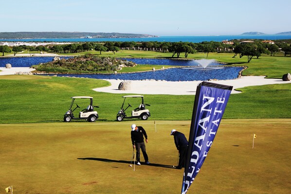 A golf course with a water hazard, a flag, and a golf cart. - Ellefsen Golf Suite 115, Langebaan 4-Sleeper (Langebaan)