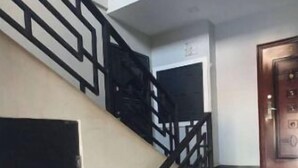 Un escalier avec des rampes noires et un mur blanc.
