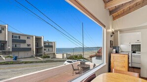 Une cuisine moderne avec des meubles blancs et une vue sur l’océan.