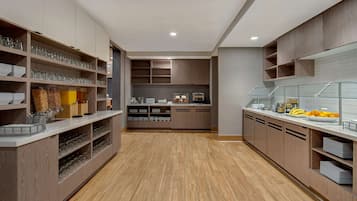 Uma cozinha moderna com armários de madeira, uma ilha central e uma vitrine de vidro.