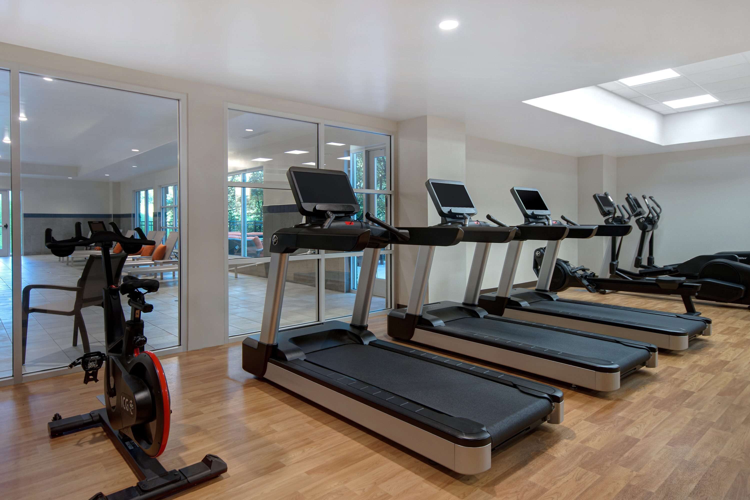 A gym with treadmills, stationary bikes, and a rowing machine.