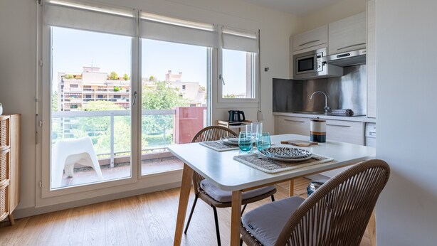A modern kitchen with a microwave, stove, and dishwasher. - LE NID DES CEDRES - Magnifique Studio terrasse Montplaisir (Lyon)