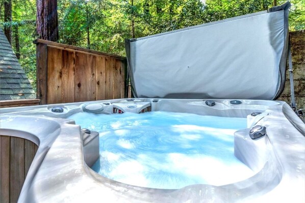 Un jacuzzi con terraza de madera y una valla de madera al fondo.