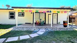 A house with a covered patio, a satellite dish, and colorful flags. - Join Us For A Fiesta! - Central San Antonio (San Antonio)