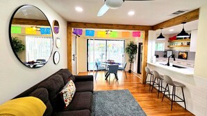 A living room with a sofa, a coffee table, and a dining area with chairs and a table. - Join Us For A Fiesta! - Central San Antonio (San Antonio)