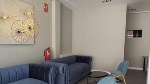 A modern living room with a blue sofa set, a small round table, and a blue armchair. - Micampus Burgos Centro (Burgos)