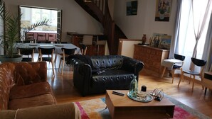 Ein Wohnzimmer mit einer schwarzen Ledersofa, einem braunen Leder-Couch, einem Holztisch und einem Essbereich mit Tisch und Stühlen.