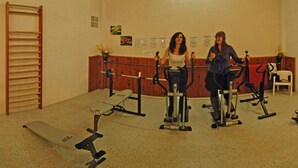 Un gimnasio con bicicletas estáticas y una cinta de correr.