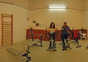 A gym with stationary bikes and a treadmill.