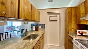 Una cocina con armarios de madera, un lavamanos de acero inoxidable y un horno empotrado.
