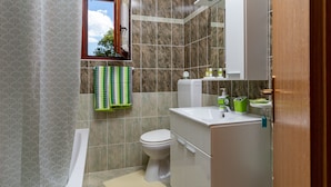 Ein modernes Badezimmer mit Toilette, Waschbecken und Spiegel.