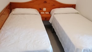 Un lit double avec une tête de lit en bois et une literie blanche.