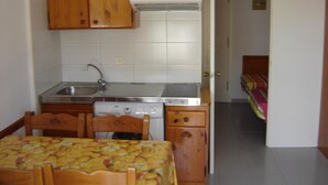 A compact kitchen with wooden cabinets, a stainless steel sink, and a built-in dishwasher. - Apartment 2/4 sea view (L'Estartit)
