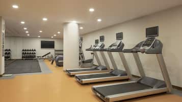 A gym with treadmills, weights, and exercise balls.