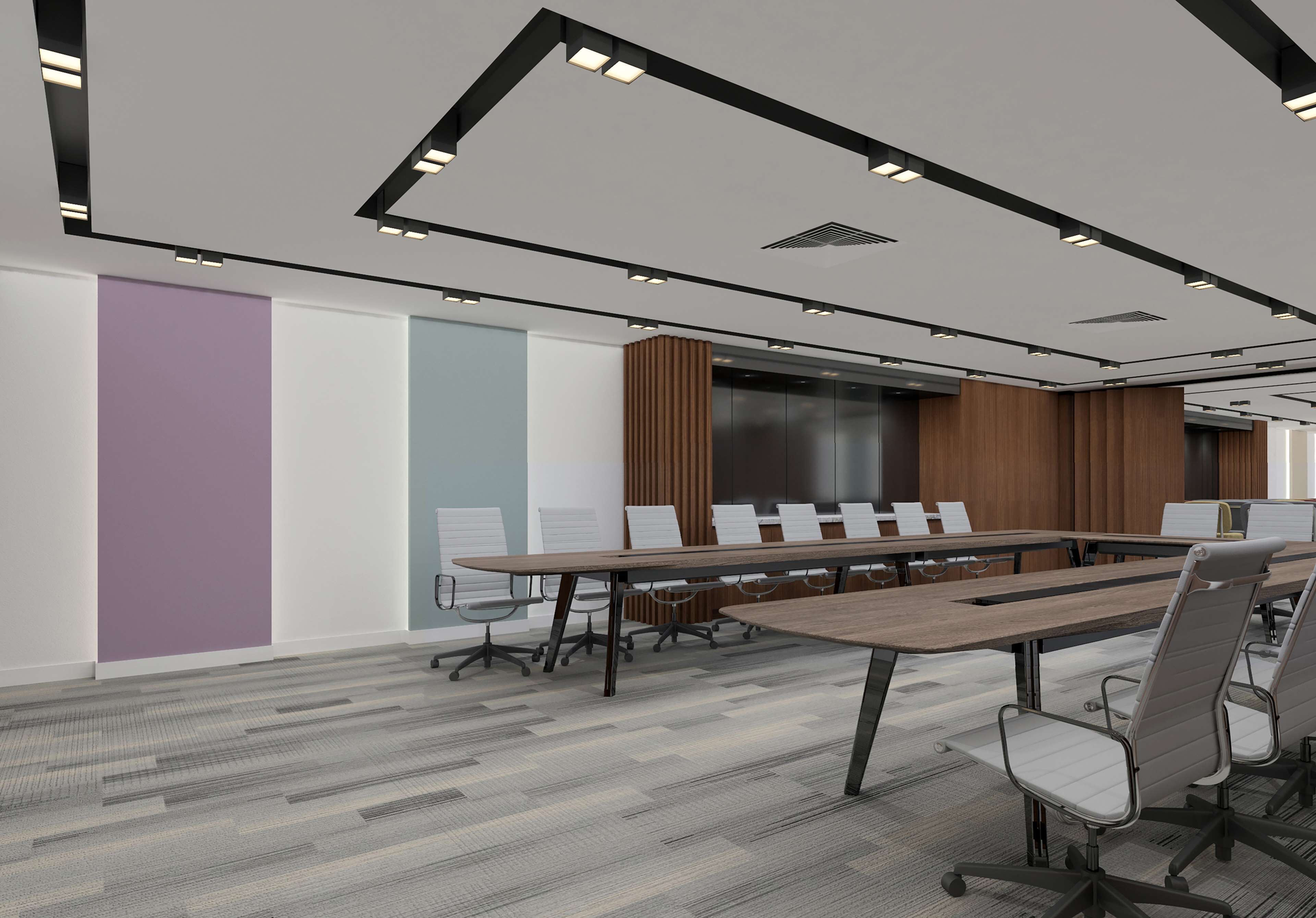 Una sala de conferencias moderna con una larga mesa, sillas y una pantalla grande.