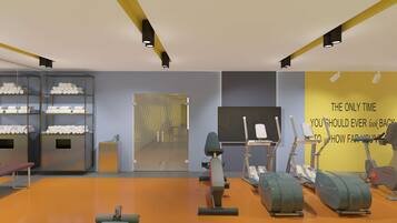 A gym with exercise equipment, a bench, and a wall with motivational text.