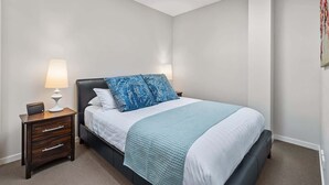 A bedroom with a bed, bedside tables, a lamp, and a ceiling light. - Chic Inner City Convenience, with Secure Parking (South Melbourne)