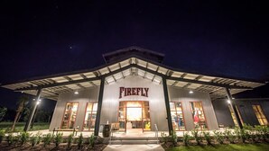A building with a prominent 'Firefly' sign, large windows, and a covered entrance area. - Covered patio, fenced back yard, open floor plan (North Charleston)