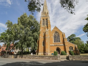 A church with a tall spire, large arched windows, and a stone facade. - Cuckoo Cottage (Worcester)