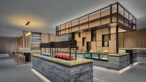 A modern hotel lobby with a marble reception desk, seating area, and a buffet with various food items. - Holiday Inn Hotel and Suites Kunshan Huaqiao by IHG (Suzhou)