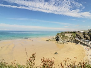 A beach with clear skies, a sandy shore, and rocky cliffs. - 30 Cliff Edge (Newquay)