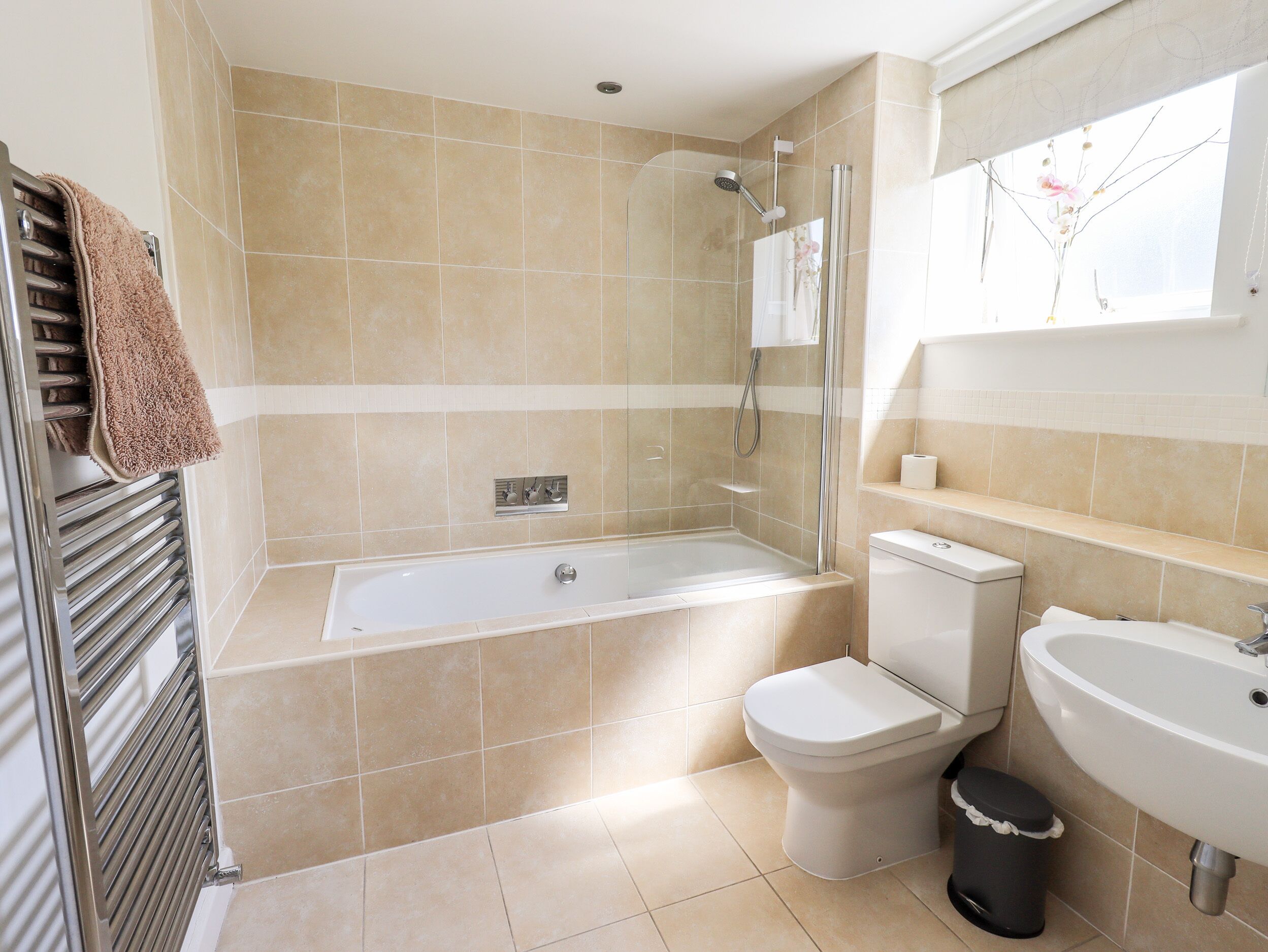 A modern bathroom with a bathtub, toilet, and sink.