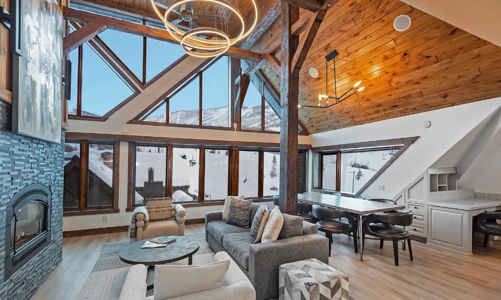 Un loft espacioso con techos altos, vigas de madera a la vista, una chimenea grande y vistas panorámicas a las montañas.