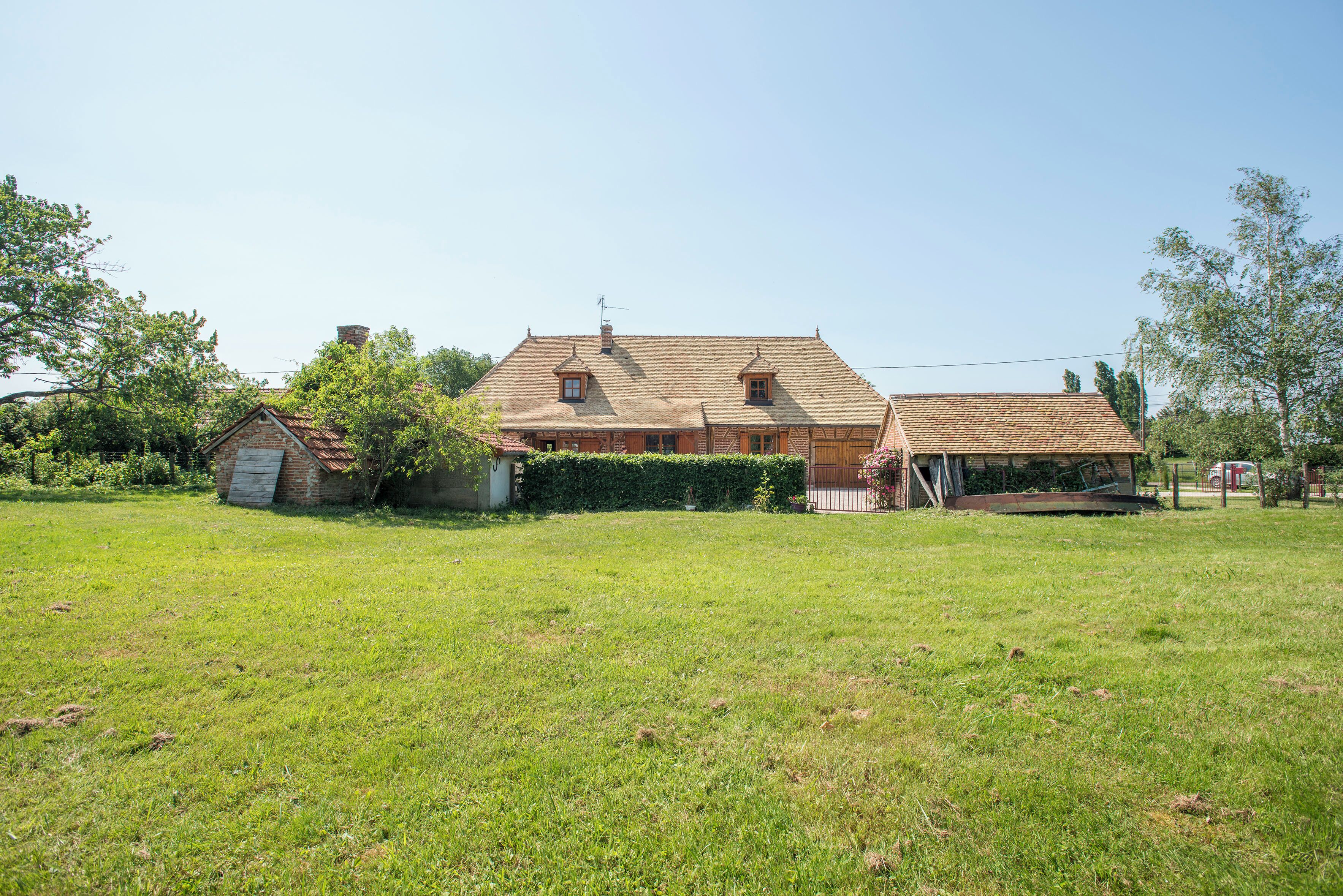 A large house with a spacious backyard, a small shed, and a well-maintained lawn.