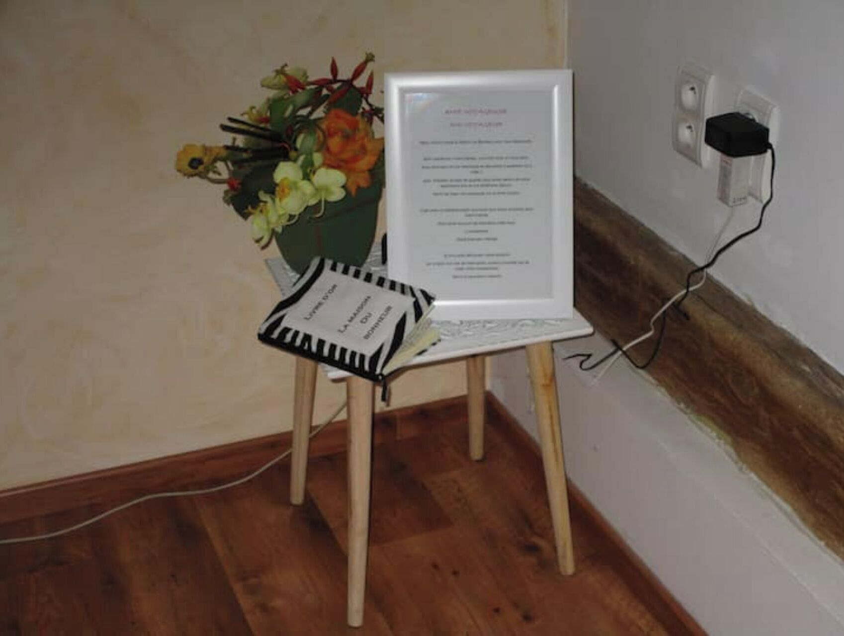 Een laptop op een houten stoel, met een boeket bloemen ernaast.