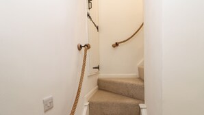 A carpeted staircase with a rope toy hanging from the wall. - The Old Store, 2 Alpine Terrace (Richmond)