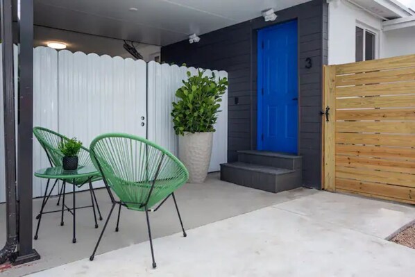 outdoor space with a potted plant and two chairs.