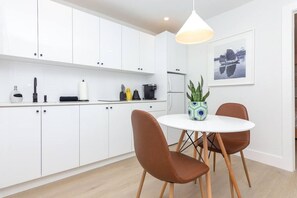 Enjoy meals in this kitchen with a central island, round dining table, and pendant light.