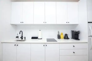 Enjoy cooking in this well-equipped kitchen with a sink, coffee maker, and kettle.