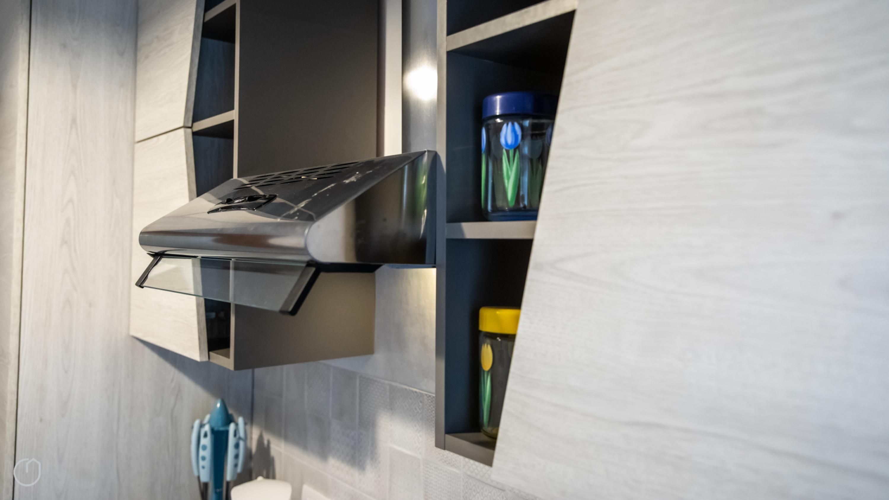 Una cucina moderna con piano cottura integrato, forno a microonde e dispenser d'acqua.