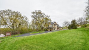 A large, two-story house with a well-maintained lawn and a driveway leading to the entrance. - Magnificently restored, charming, 8+ Bed-Victorian on a beautiful 1.5 acres. (Waukesha)