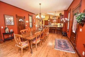 A dining room with a wooden table and chairs, a chandelier, and a rug. - Magnificently restored, charming, 8+ Bed-Victorian on a beautiful 1.5 acres. (Waukesha)