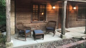 A wooden cabin with a porch, two wicker chairs, and a small table. - Beautifully Restored Historic Victorian (Waukesha)