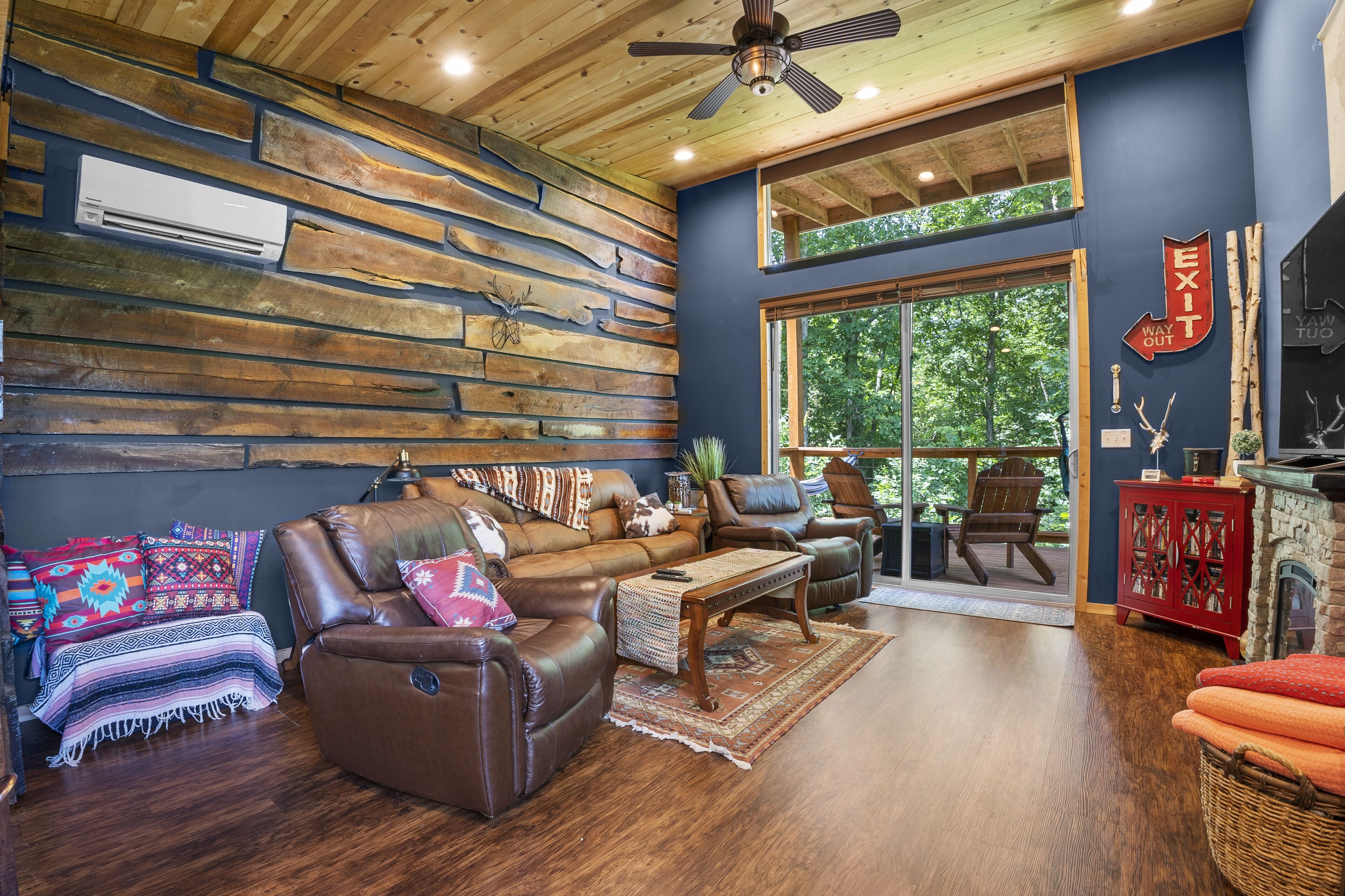 A cozy living room with a brown leather sofa, a wooden coffee table, and a fireplace.