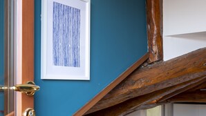 A staircase with a wooden handrail leading to a white door. A framed artwork is mounted on the wall above the staircase. - Fosca Venice Rooms (Venice)