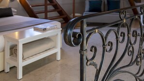 A cozy attic bedroom with a wooden staircase, a white bed, and a small white table. - Fosca Venice Rooms (Venice)