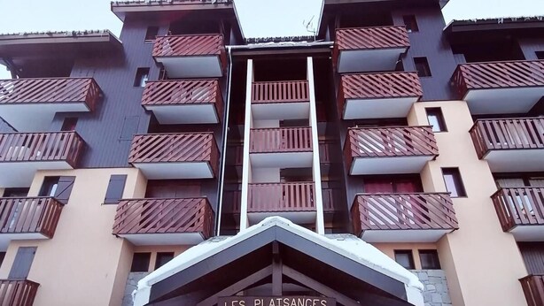 Un immeuble à plusieurs étages, avec une enseigne indiquant « LES PLAISANCES » à l’entrée.