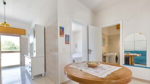 Una cucina moderna con un tavolo rotondo, mobili bianchi e vista sull'area pranzo.
