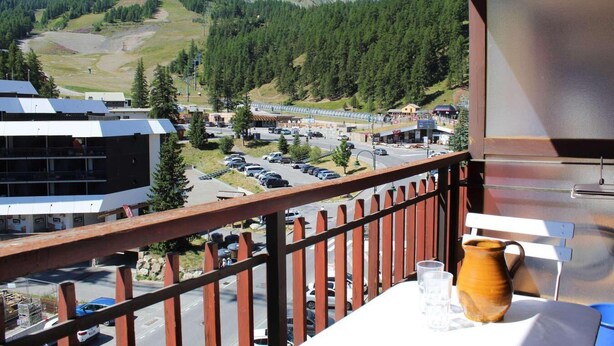 A balcony with a view of a parking lot, buildings, and mountains. - 100m from ski slopes, 5th floor, tv, 30m², Vars (Vars)