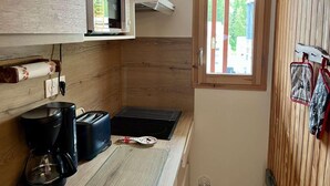 A compact kitchen with a microwave, coffee maker, toaster, and a small window. - 100m from ski slopes, 5th floor, tv, 30m², Vars (Vars)