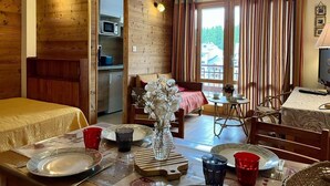 A cozy room with a bed, a dining table set for two, a small kitchen, and a balcony with curtains. - 100m from ski slopes, 5th floor, tv, 30m², Vars (Vars)