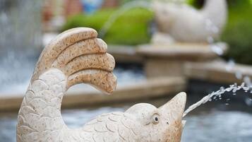 A stone fish sculpture with water flowing from its mouth.