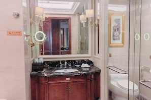 A bathroom with a marble vanity, a large mirror, a framed picture, and a glass shower enclosure. - Hubei Culture and Tourism Honglian Lake Hotel (Ezhou)